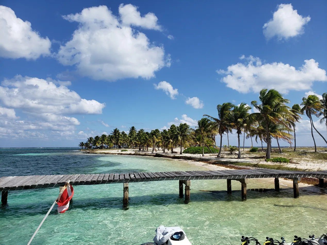 Belize dock with dive flag and gear.
